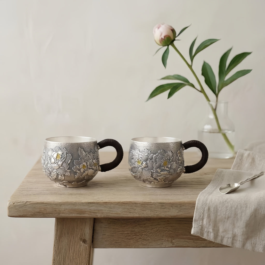 Reine 999 Feinsilber Elegante handgefertigte Teetassen aus Silber mit detailliertem Pfingstrosenrelief und traditionellen geflochtenen Griffen – Handarbeit