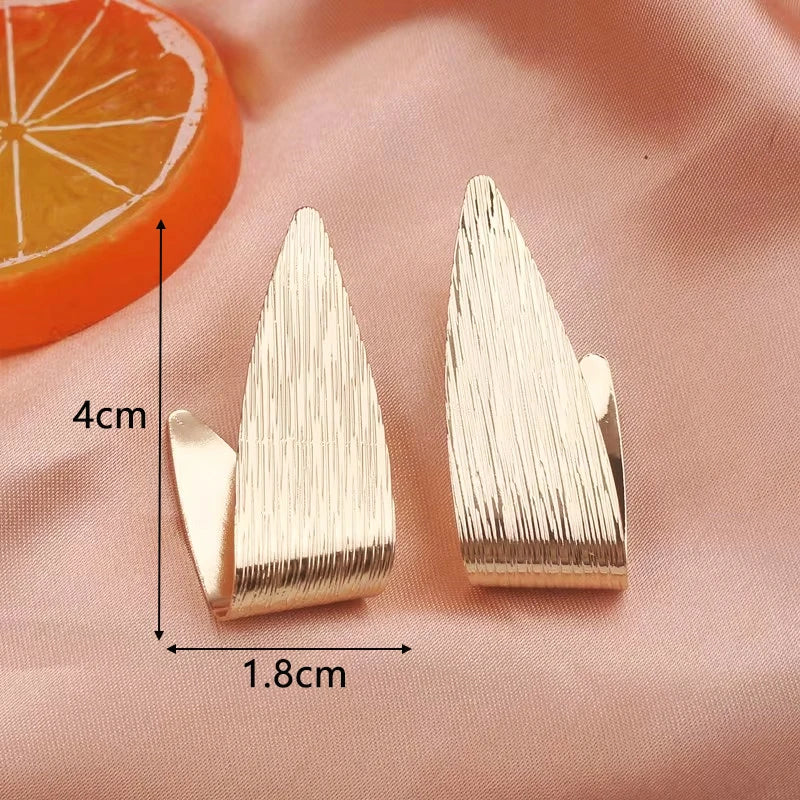 Goldfarbene Metall-Tropfenohrringe Unregelmäßige hohle Herz-Anhänger-Ohrringe Gedrehte geometrische Persönlichkeits-Ohrringe für Frauen