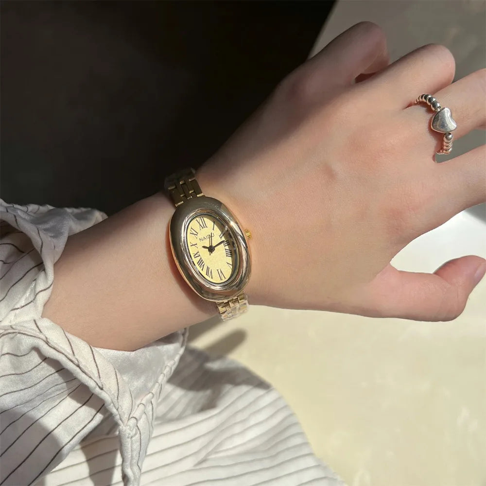 Reloj de moda Hot Sale para mujer, estilo de la antigua Roma, esfera ovalada, reloj pequeño dorado, correa de acero ajustable, reloj de pulsera de cuarzo al por mayor