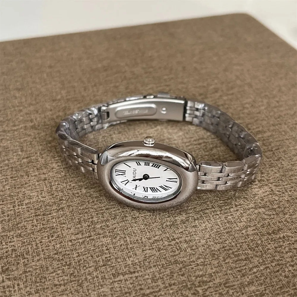 Reloj de moda Hot Sale para mujer, estilo de la antigua Roma, esfera ovalada, reloj pequeño dorado, correa de acero ajustable, reloj de pulsera de cuarzo al por mayor