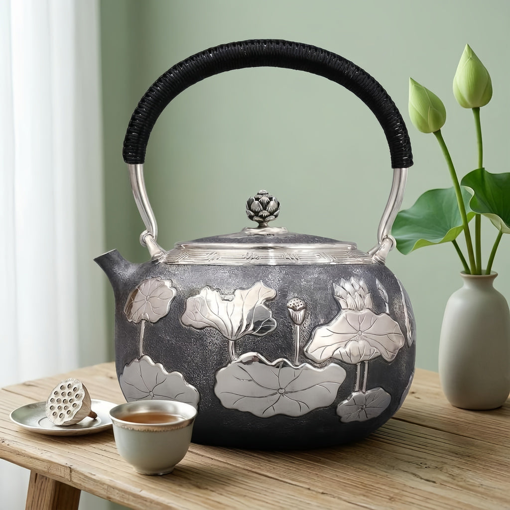 Teekanne aus 925er Sterlingsilber, handgefertigt, mit geprägtem Lotus-Teich-Motiv und schwarzem Kordelgriff - Kunsthandwerk